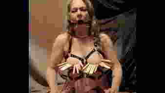 Bőr hámban megkötözve és szájfeszítővel megalázva, a rabszolga nő kényszerszopása és belebörgölés